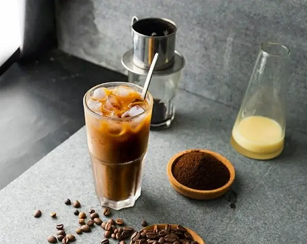 Cafe Sữa Đá, or Vietnamese iced coffee with milk, is a sweet and creamy beverage synonymous with Vietnamese coffee culture. Combining strong, dark coffee with sweetened condensed milk creates a delightful contrast of flavors that has captured the hearts of locals and visitors alike.